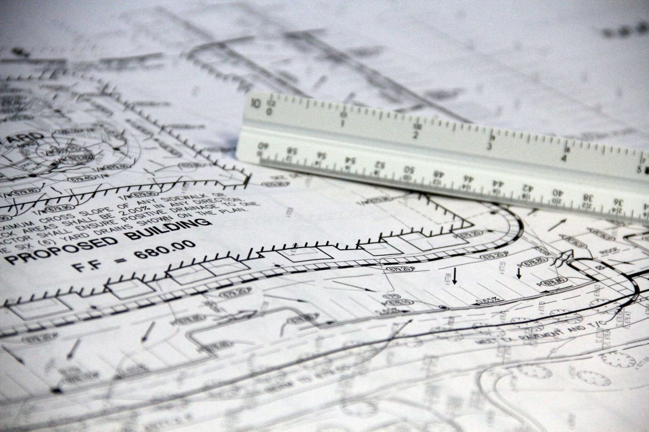 Crafting Captivating Headlines: Your awesome post title goes here Detailed close-up of architectural blueprints with scale ruler, showing building plans and measurements.